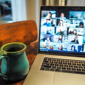 people on a video conference meeting with a cup of coffee beside a laptop